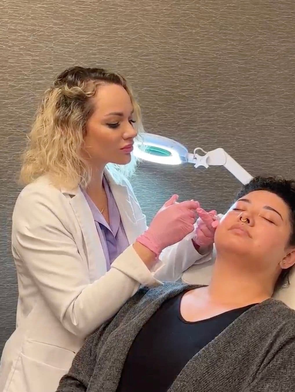 Liza Nikitsina, MSN, APRN, FNP-C injecting a client with filler