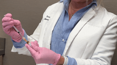 Provider administering mesotherapy mesoneedling treatment to a woman